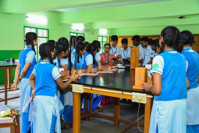 Students gathered around a physics laboratory bench
